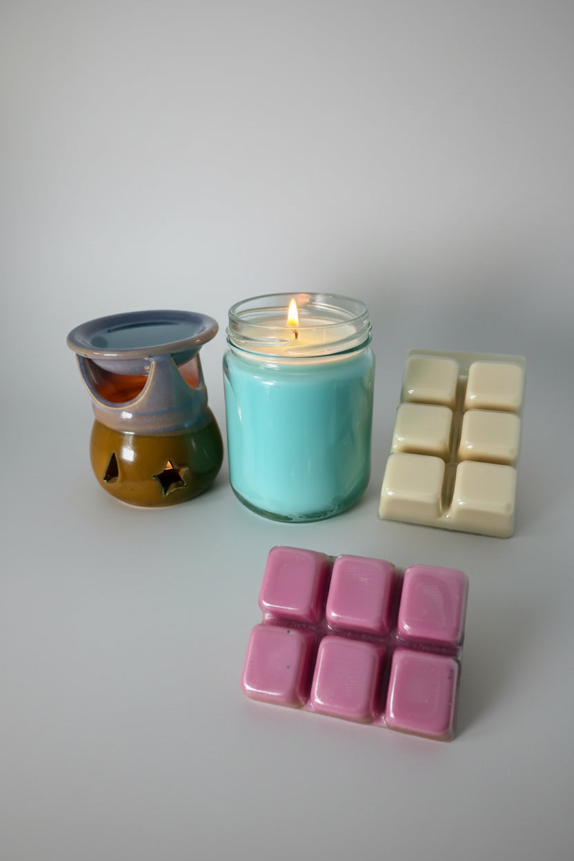 Candle and wax melts on a wooden surface with a white background